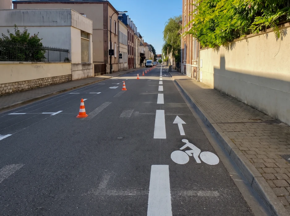 Passage piéton en marquage au sol blanc, vue en perspective sur voirie asphaltée en courbe