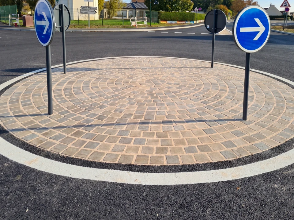 Panneau directionnel vert foncé en zone d'activités, implanté en bordure de route