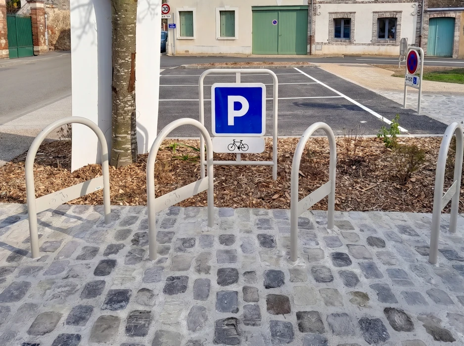Panneau directionnel vert d'une zone d'activités commerciales, en extérieur, sur fond de végétation et route
