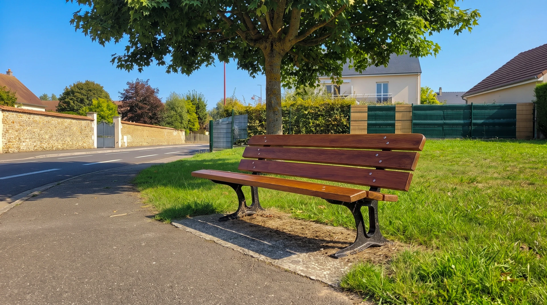 Photographie réaliste d'un espace public aménagé montrant plusieurs éléments de mobilier urbain : au premier plan, un abribus moderne aux parois vitrées avec structure métallique, au second plan un banc public en acier et bois, une poubelle de voirie cylindrique en acier laqué, tous installés sur une place ou un trottoir pavé urbain. L'ensemble doit refléter un espace public bien équipé et fonctionnel, sans personne visible, photographié en lumière naturelle de jour.