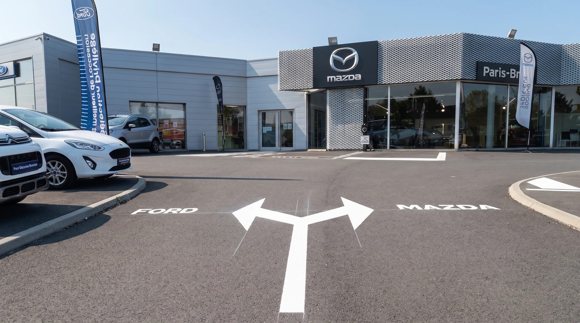 Route neuve à deux voies séparées par une bande centrale rouge bordeaux, délimitée par des marquages blancs continus