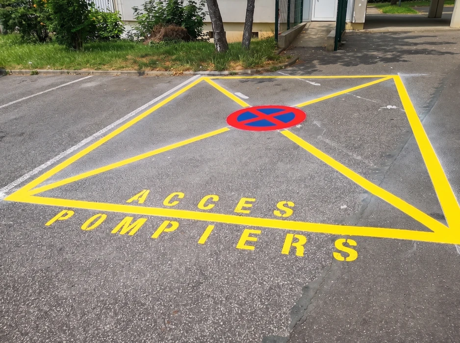 Parking neuf en enrobé bitumineux noir, vue extérieure d'un bâtiment tertiaire